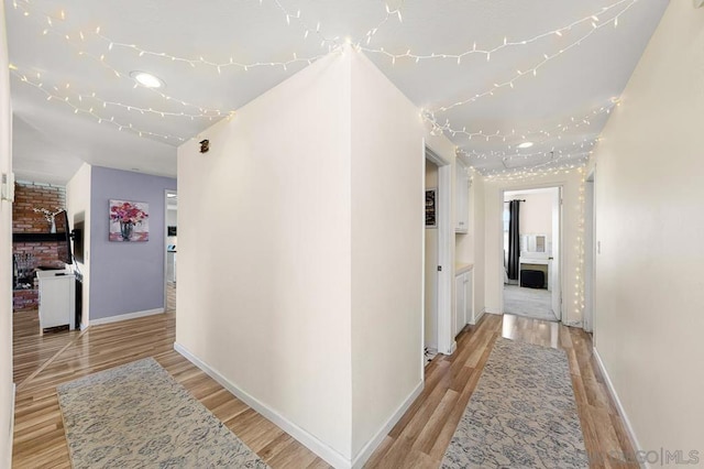 hallway with light hardwood / wood-style floors