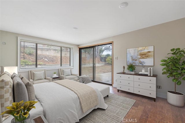 bedroom featuring multiple windows, dark wood-type flooring, and access to outside