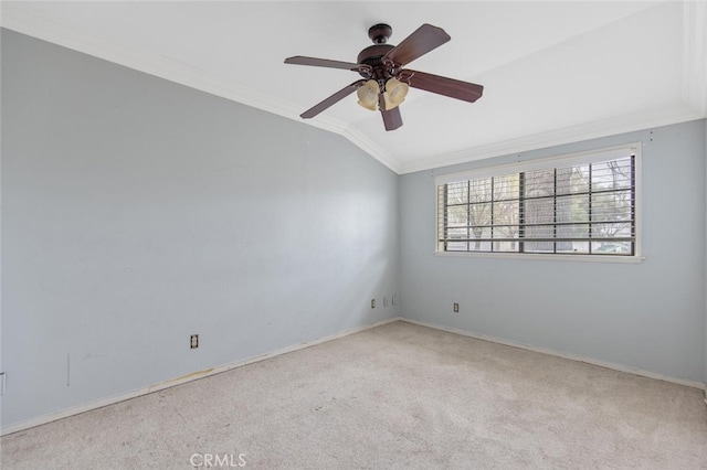 empty room with vaulted ceiling, light carpet, ceiling fan, and crown molding