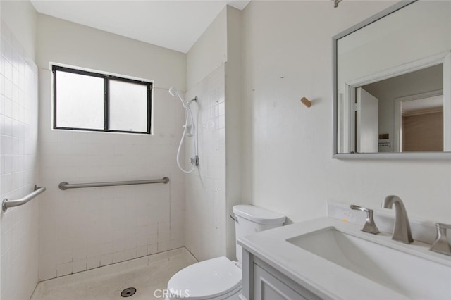 bathroom featuring tiled shower, vanity, and toilet