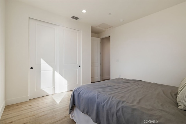 bedroom with light hardwood / wood-style floors and a closet