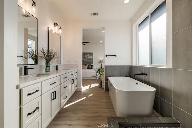 bathroom featuring a tub to relax in, wood-type flooring, and vanity