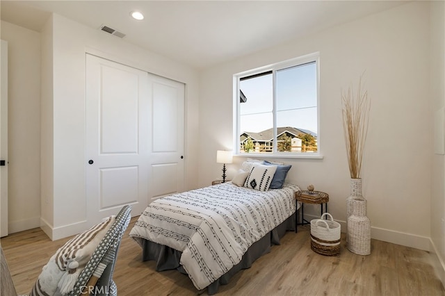 bedroom with light hardwood / wood-style flooring and a closet