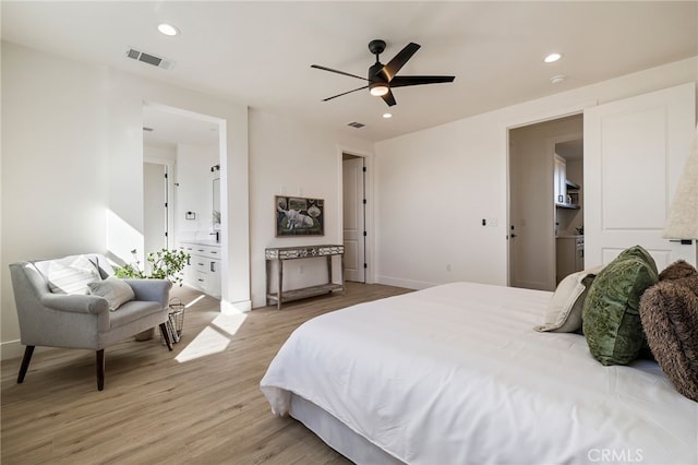 bedroom with ceiling fan, ensuite bath, and light hardwood / wood-style flooring