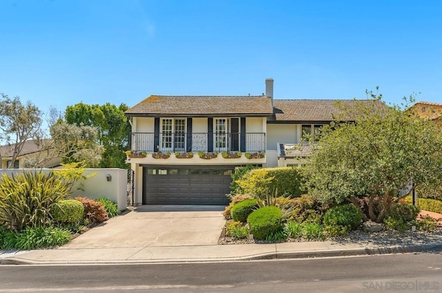 view of front of property featuring a balcony and a garage