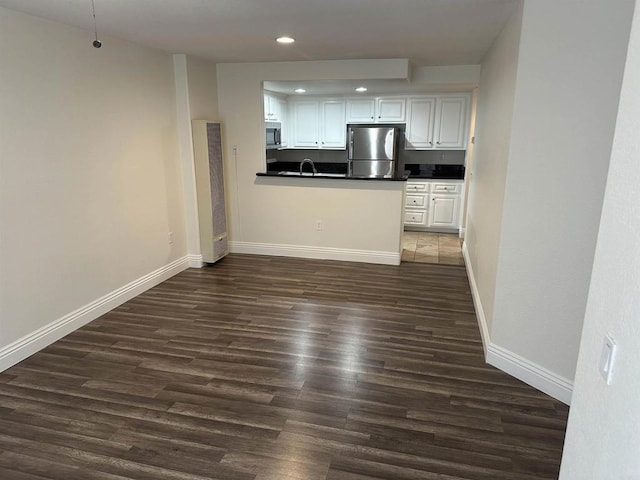 unfurnished living room featuring dark hardwood / wood-style flooring and sink