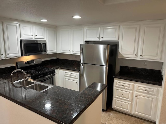 kitchen with kitchen peninsula, white cabinets, and appliances with stainless steel finishes