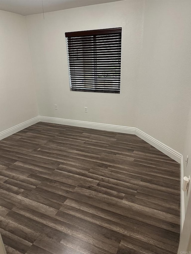 unfurnished room with dark hardwood / wood-style flooring