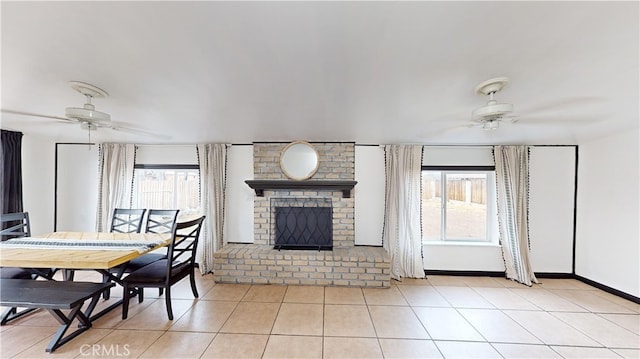 dining space featuring a wealth of natural light, a fireplace, and ceiling fan