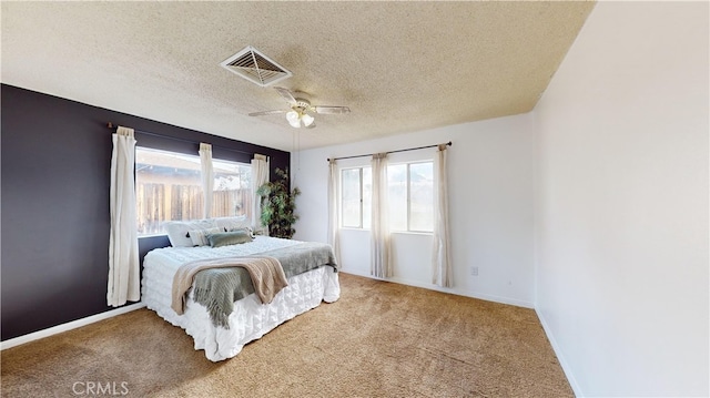 bedroom with light carpet, ceiling fan, and a textured ceiling