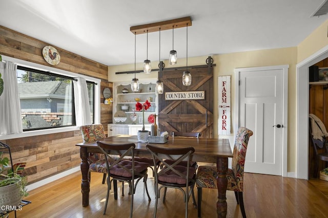 dining area featuring hardwood / wood-style floors and wooden walls