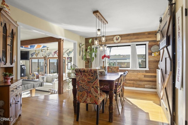 dining area with light hardwood / wood-style flooring and wood walls