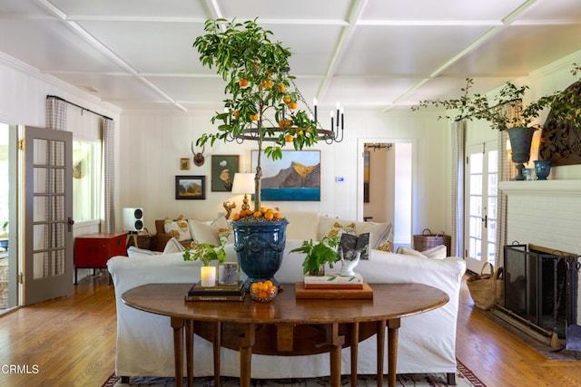 dining area with hardwood / wood-style flooring, a brick fireplace, and french doors