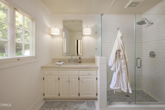 bathroom with vanity and a shower with door