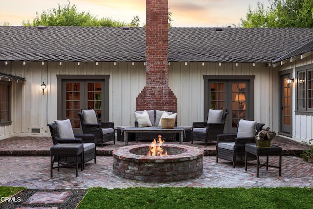 patio terrace at dusk featuring an outdoor living space with a fire pit and french doors