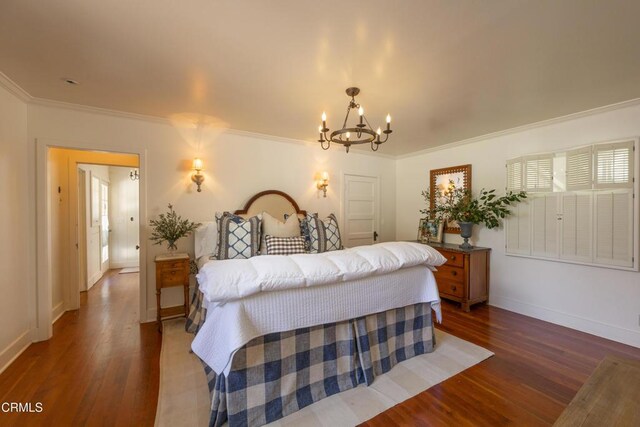 bedroom featuring dark hardwood / wood-style flooring, crown molding, and a chandelier