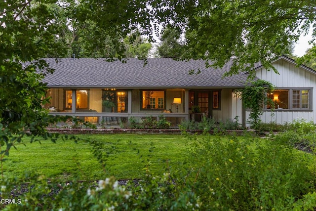 rear view of house featuring a lawn