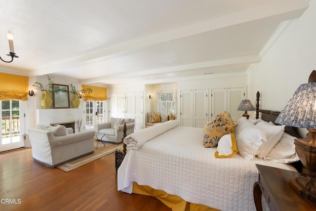 bedroom featuring beam ceiling, hardwood / wood-style flooring, access to outside, and ornamental molding