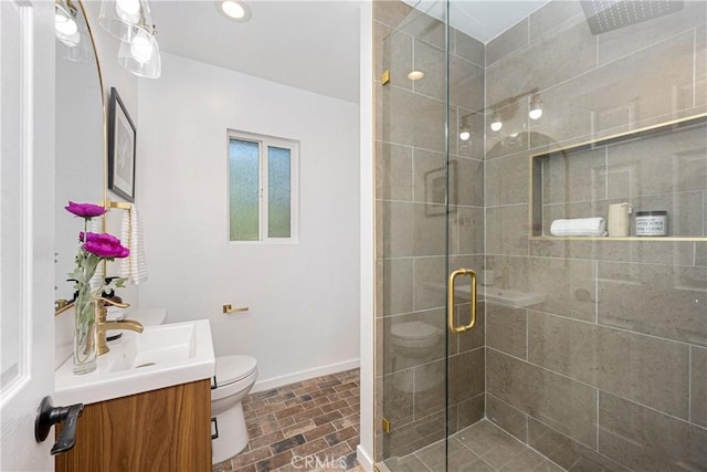 bathroom featuring vanity, toilet, and a shower with door