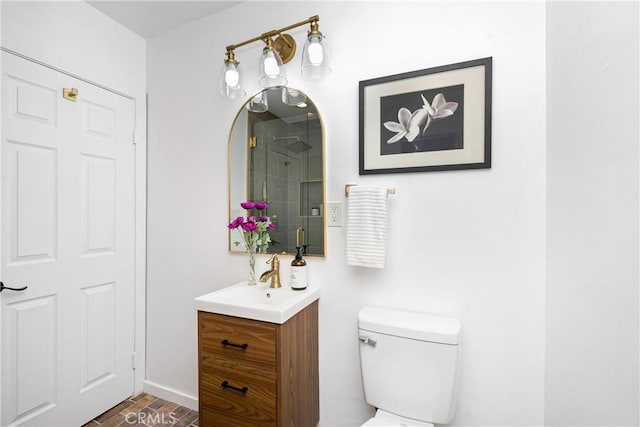 bathroom featuring a shower with door, vanity, and toilet