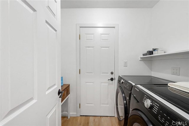 laundry area with washer and clothes dryer and light wood-type flooring