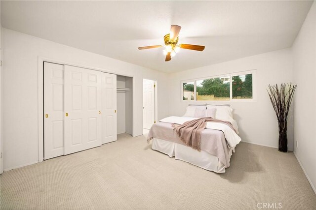 carpeted bedroom with ceiling fan and a closet