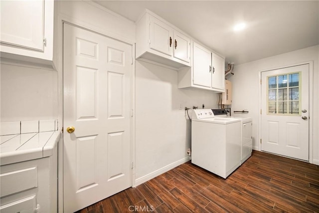 laundry room with dark wood-type flooring, cabinets, separate washer and dryer, and water heater