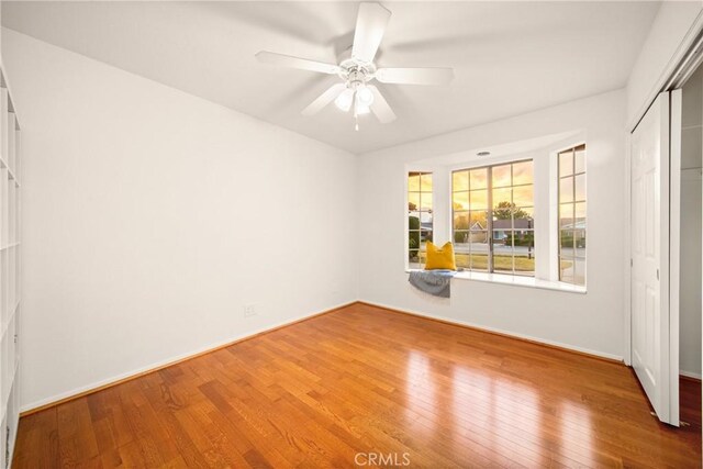 unfurnished bedroom with hardwood / wood-style floors, ceiling fan, and a closet