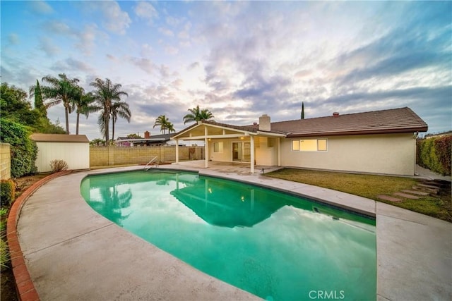 view of pool with a patio and a storage unit