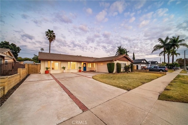 single story home with a garage and a lawn