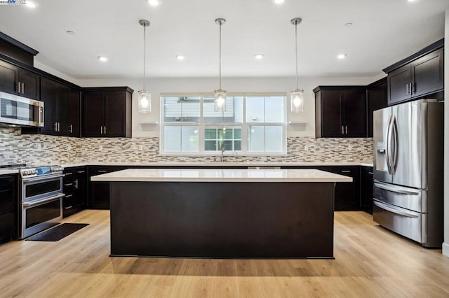 kitchen with pendant lighting, stainless steel appliances, and a center island