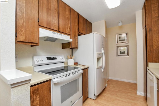 kitchen featuring white appliances and light hardwood / wood-style floors