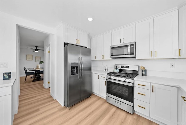 kitchen featuring white cabinetry, appliances with stainless steel finishes, ceiling fan, and light wood-type flooring