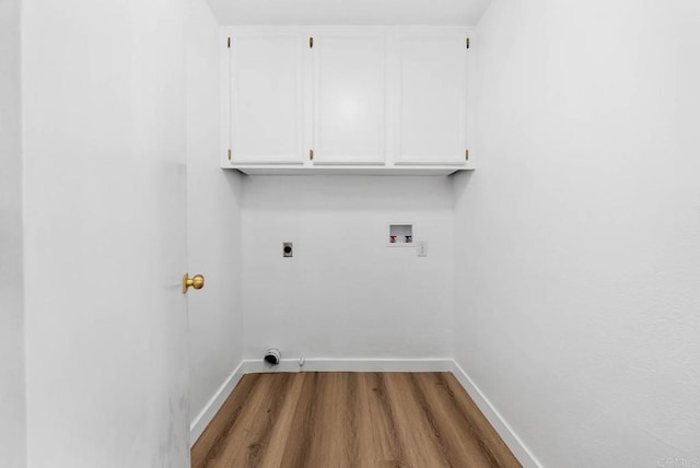 clothes washing area featuring hardwood / wood-style flooring, cabinets, washer hookup, and hookup for an electric dryer