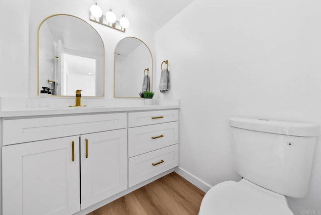 bathroom featuring vanity, wood-type flooring, and toilet