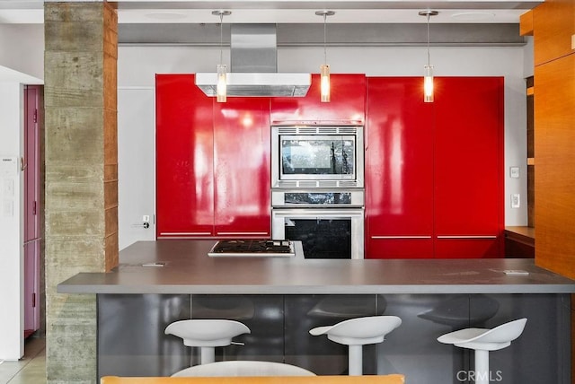 kitchen with decorative light fixtures, wall chimney exhaust hood, and appliances with stainless steel finishes