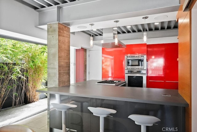 kitchen with stainless steel appliances, island exhaust hood, light tile patterned flooring, and kitchen peninsula