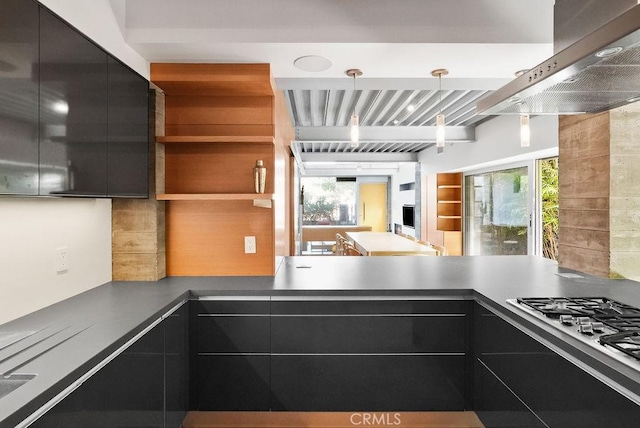 kitchen featuring gas stovetop, island range hood, a wealth of natural light, and decorative light fixtures