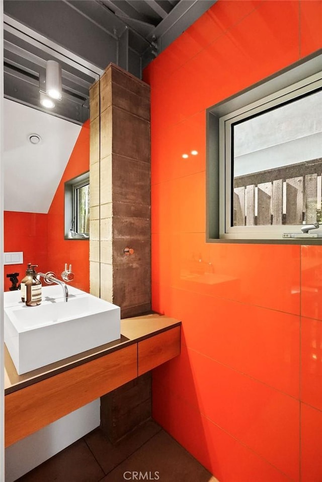 bathroom featuring lofted ceiling and sink