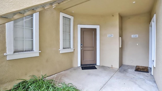 view of exterior entry with a patio area