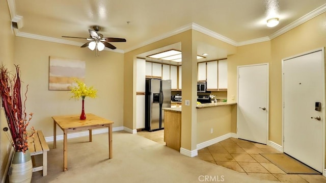 kitchen with white cabinets, light tile patterned floors, kitchen peninsula, stainless steel appliances, and crown molding