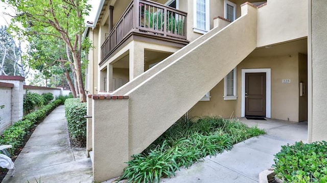 view of exterior entry featuring a balcony