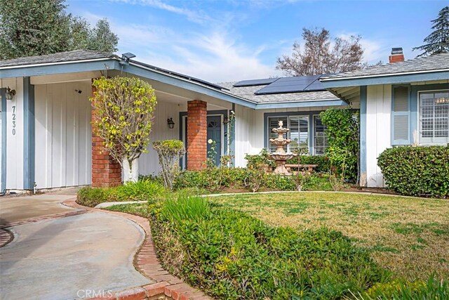7230 Sarsaparilla Dr, Corona, CA 92881 - entrance to property with solar panels, a lawn, brick siding, board and batten siding, and a shingled roof
