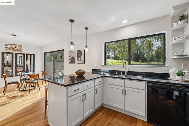 kitchen with white cabinetry, dishwasher, hanging light fixtures, and sink