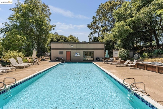 view of pool with a patio and an outdoor structure