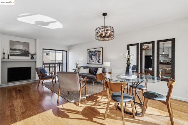 dining area with an inviting chandelier and light hardwood / wood-style flooring