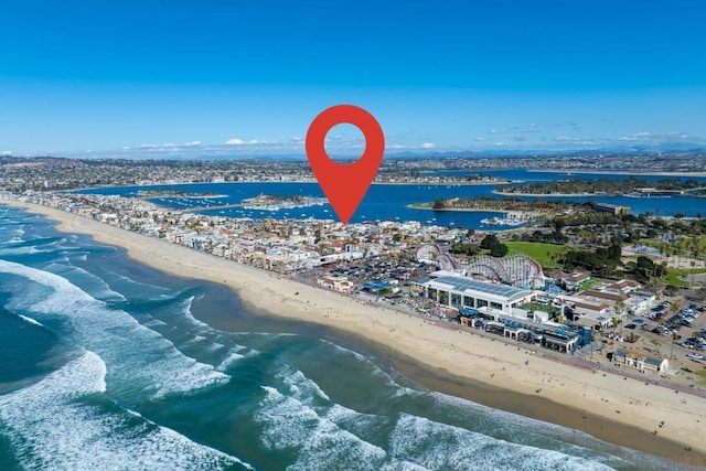 bird's eye view featuring a water view and a beach view