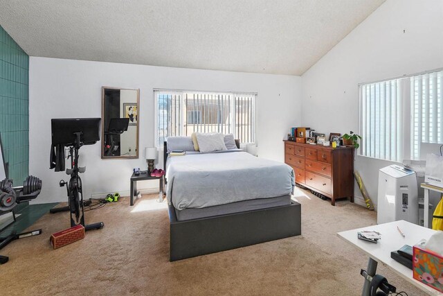 bedroom featuring vaulted ceiling, light colored carpet, and a textured ceiling