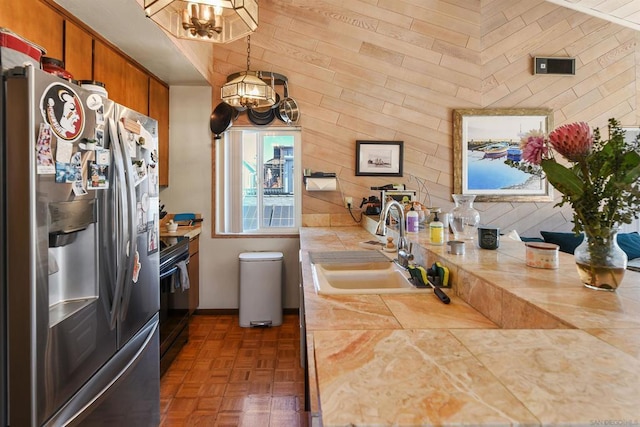 kitchen featuring stainless steel refrigerator with ice dispenser, dark parquet flooring, sink, black electric range, and pendant lighting