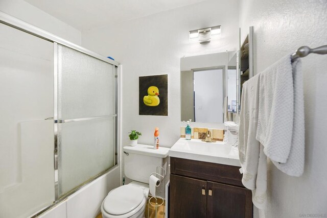 full bathroom featuring enclosed tub / shower combo, vanity, and toilet